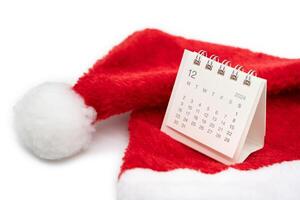 Simple desk calendar for DECEMBER 2024 with Santa hats on white background. New year Calendar concept with copy space. 2024 DEC calendar. photo