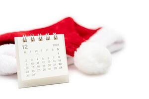Simple desk calendar for DECEMBER 2024 with Santa hats on white background. New year Calendar concept with copy space. 2024 DEC calendar. photo