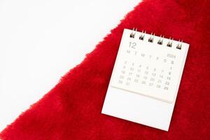 Simple desk calendar for DECEMBER 2024 with Santa hats on white background. New year Calendar concept with copy space. 2024 DEC calendar. photo