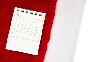 Simple desk calendar for DECEMBER 2024 with Santa hats on white background. New year Calendar concept with copy space. 2024 DEC calendar. photo