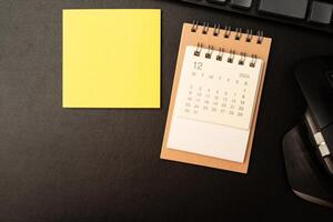 Simple desk calendar for December 2024 on desk with office supplies. Calendar concept with copy space. 2024 DEC calendar. photo