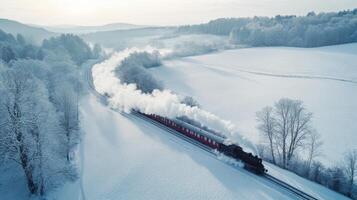 Winter train in frosty landscape, scenic snow-covered aerial view. Aerial view train passing through photo