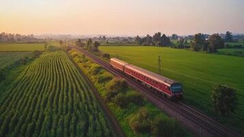Aerial view of train by villages and fields, tranquil rural setting. Aerial view train passing through photo