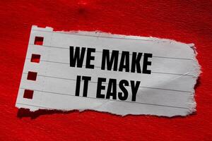 We make it easy message written on ripped torn paper piece with red background. Conceptual we make it easy symbol. Copy space. photo