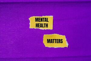 Mental health matters message written on ripped torn yellow paper pieces with purple background. Conceptual mental health matters symbol. Copy space. photo