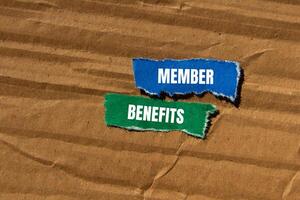 Member benefits message written on ripped torn paper pieces with cardboard background. Conceptual member benefits symbol. Copy space. photo