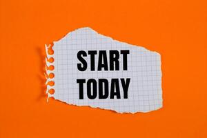 Start today message written on ripped torn checkered graph paper piece with orange background. Conceptual start today symbol. Copy space. photo