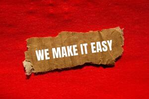 We make it easy message written on ripped torn cardbaord paper piece with red background. Conceptual we make it easy symbol. Copy space. photo