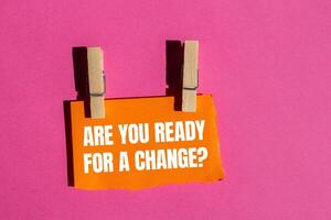 Are you ready for a change message written on ripped torn orange paper piece with pink background. Conceptual are you ready for a change symbol. Copy space. photo