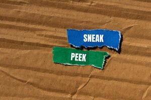 Sneak peek message written on ripped torn paper pieces with cardboard background. Conceptual sneak peek symbol. Copy space. photo