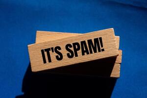 It's spam message written on wooden blocks with blue background. Conceptual it's spam symbol. Copy space. photo