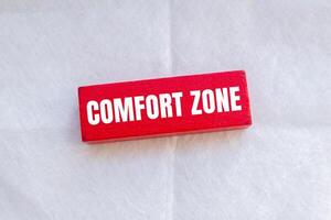 Comfort zone message written on wooden red block with white background. Conceptual comfort zone symbol. Copy space. photo