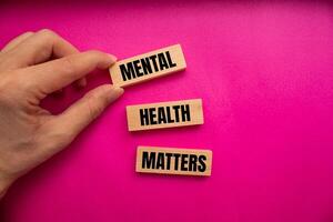 Mental health matters message written on wooden blocks with pink background. Conceptual mental health matters symbol. Copy space. photo