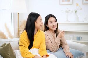 Two female teenager watching television at the hostel on holiday trip. photo