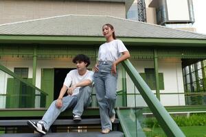 Young couple posing on stairs in front of green colonial building photo