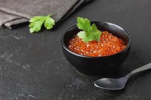Red salmon caviar with parsley in a bowl photo