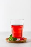Raspberry drink in the glass on the light background. photo