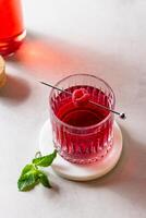 Cocktail with raspberry in a glass on a marble stand photo