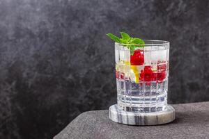 Raspberry cocktail with ice in a glass on a marble photo