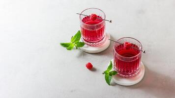 Raspberry cocktail in a glass on a marble stand photo