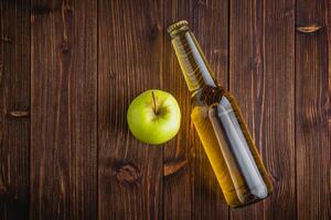 Apple cider in a bottle on a wooden table photo
