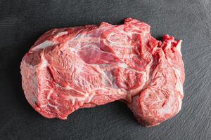 Raw beef meat on a black serving plate photo