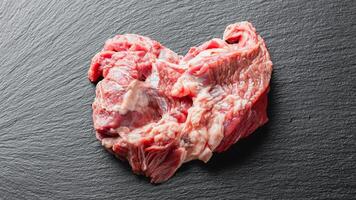 Raw beef meat on a black serving plate photo