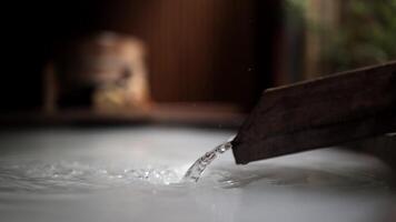 Close-up view of water flowing into a bathtub against wooden, natural background. This modern bathroom scene combines sleek design with natural elements, creating spa. Advertising. Selective focus video