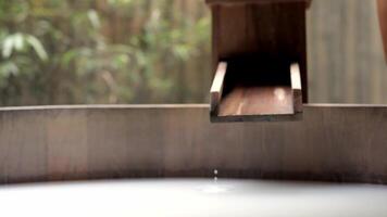 Close-up view of water flowing into a bathtub against wooden, natural background. This modern bathroom scene combines sleek design with natural elements, creating spa. Advertising. Selective focus video