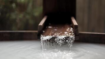 Close-up view of water flowing into a bathtub against wooden, natural background. This modern bathroom scene combines sleek design with natural elements, creating spa. Advertising. Selective focus video
