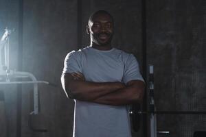 Fitness workout in gym. Portrait of African American man standing in gym with motivation health energy ready for training. Athletic coach personal trainer fitness club owner. Healthy lifestyle photo