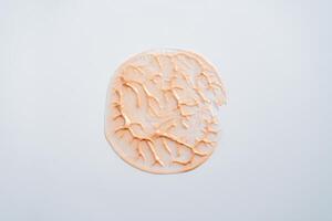 Sparkly beige cream circle with veins on white background. Minimalist makeup and body care photo