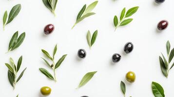 Various olives and green leaves placed on a clean white background create a fresh look photo