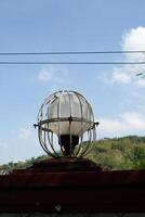 Round garden lights protected by iron frames. lights on the side of the road with a blue sky background. Copy Space. Graphic Resources. photo