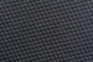 Close up of black textured fabric with repetitive pattern and geometric design background. photo