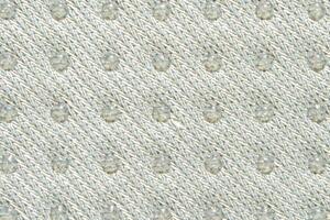 Textured knitted fabric with raised pattern in subtle beige tones for fashion and interior design applications. photo