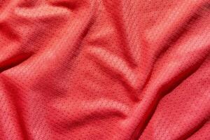 Texture of red fabric with subtle geometric patterns and soft drapery folds. photo