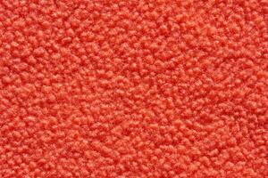 Red textured surface with soft fuzzy appearance and detailed fabric pattern. photo