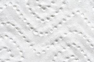 Abstract close up of white textured patterned surface with circular indentations. photo