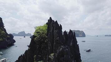 black cliffs in Lagoon on the islands, Palawan, boats Philippines. Drone view video