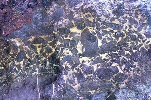 Abstract geometric pattern on rock surface with natural texture and color variations. photo