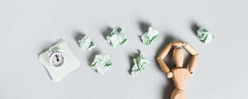 Tired man, alarm clock and crumpled papers on light background top view web banner photo
