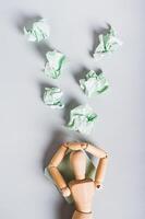 Crumpled note papers falling on burnt out man on light background top and vertical view photo