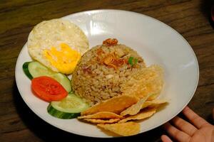 Fried rice is fried of rice and mixed with cooking oil, margarine or butter. Usually added with sweet soy sauce, shallots, garlic, sunny side egg, pepper and other ingredients. Nasi Goreng. photo