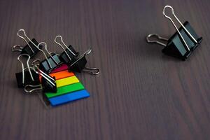 Stationery on the desk in the office. Multicolored bookmarks and paper clips. Copy space.. photo