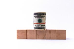 Five wooden cubes with a roll of dollars photo