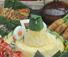 Tumpeng Sego Empog Made from mashed rice and corn and served with side dishes and vegetables photo