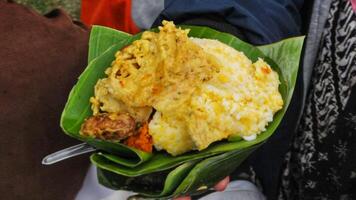 Sego Empog is a traditional food from the Malang region. Made from rice and mashed corn and served with side dishes and vegetables photo