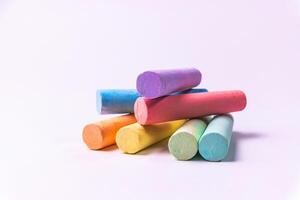 Crayons of different colors arranged on a white background. Education photo
