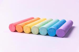 Crayons of different colors arranged on a white background. Education photo